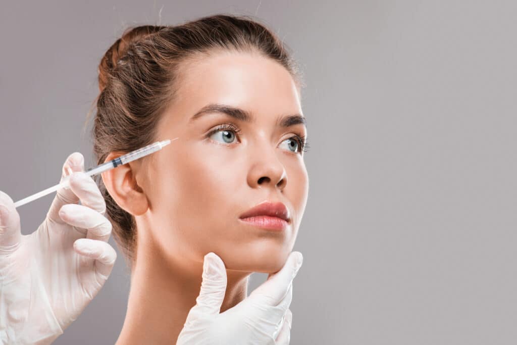 A woman getting a Dysport injection in her forehead A woman getting a Dysport injection in her forehead
